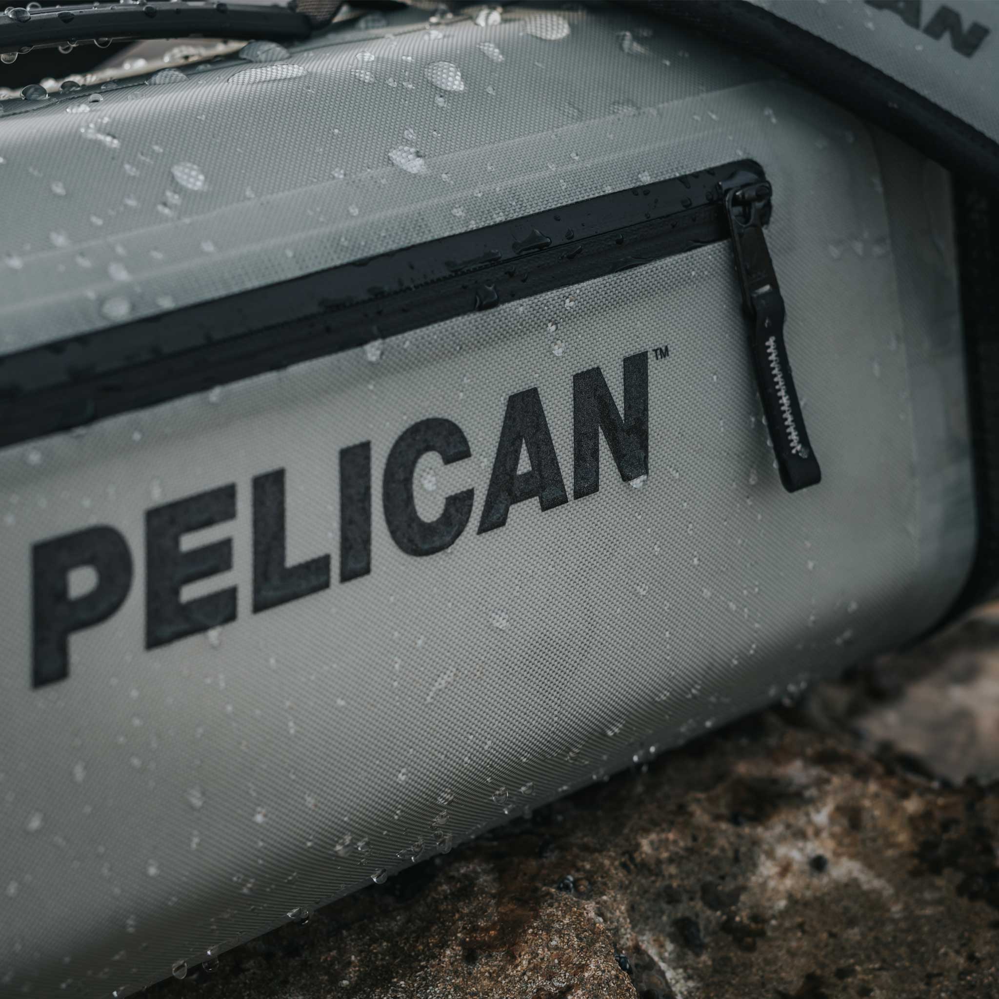 Light Grey Pelican™ Dayventure Sling Soft Cooler splashed with water