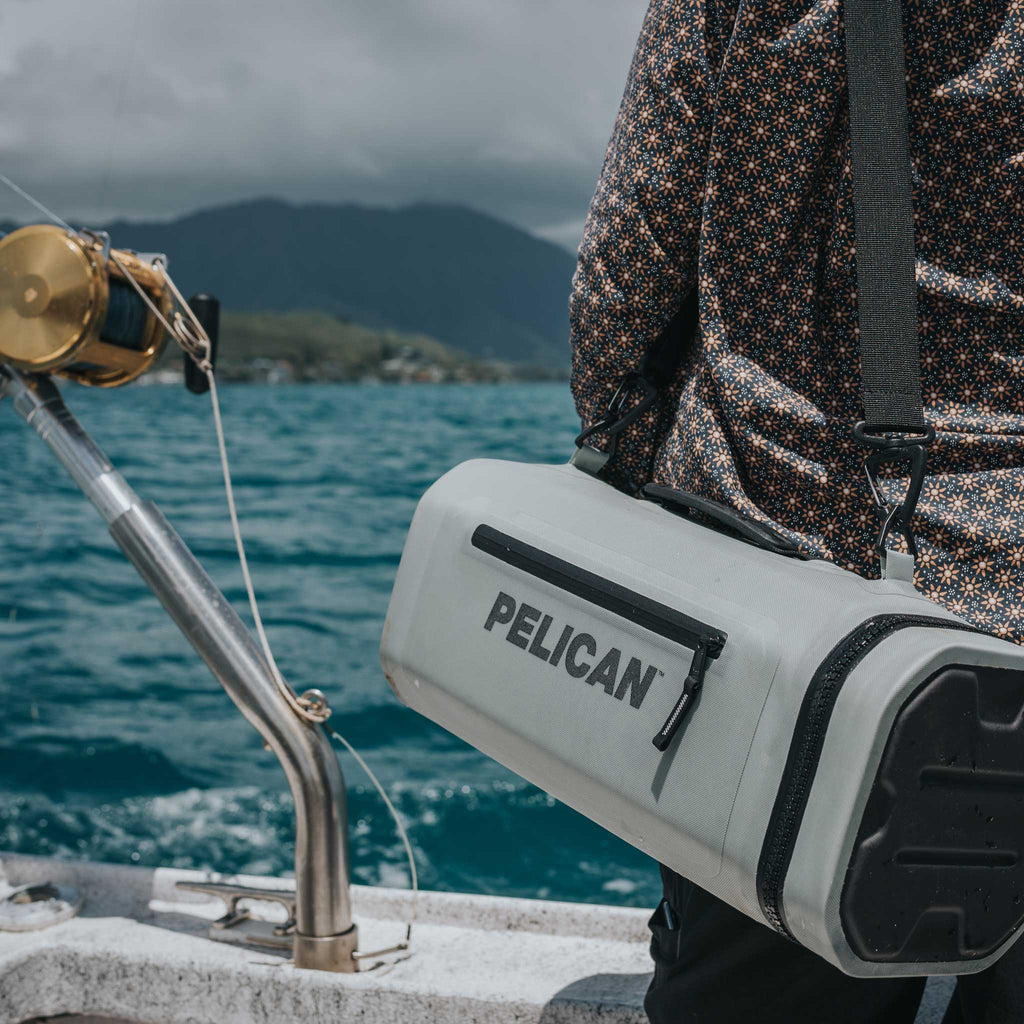 Light Grey Pelican™ Dayventure Sling Soft Cooler be used on the ocean with the strap