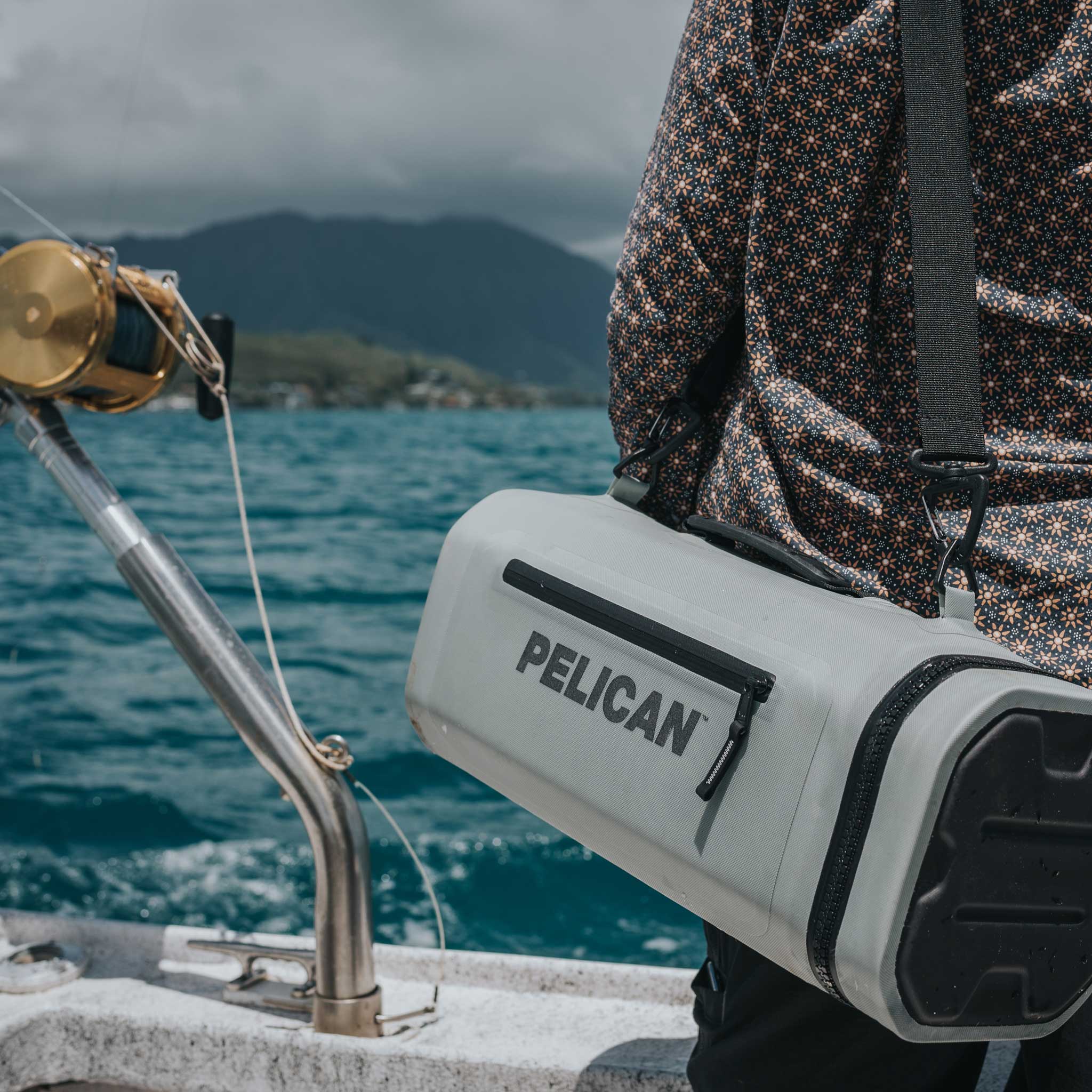 Light Grey Pelican™ Dayventure Sling Soft Cooler be used on the ocean with the strap