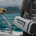 Light Grey Pelican™ Dayventure Sling Soft Cooler be used on the ocean with the strap